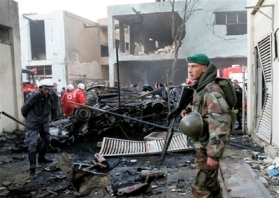 A Lebanese soldier, right, stands guard near charred cars at the site of explosion in Beirut, Lebanon, Tuesday, Jan. 15, 2008. An explosion targeted a U.S. Embassy vehicle Tuesday in northern Beirut, killing four Lebanese and injuring a local embassy employee just ahead of a farewell reception for the American ambassador, U.S. and Lebanese officials said. (AP Photo/Hussein Malla) 